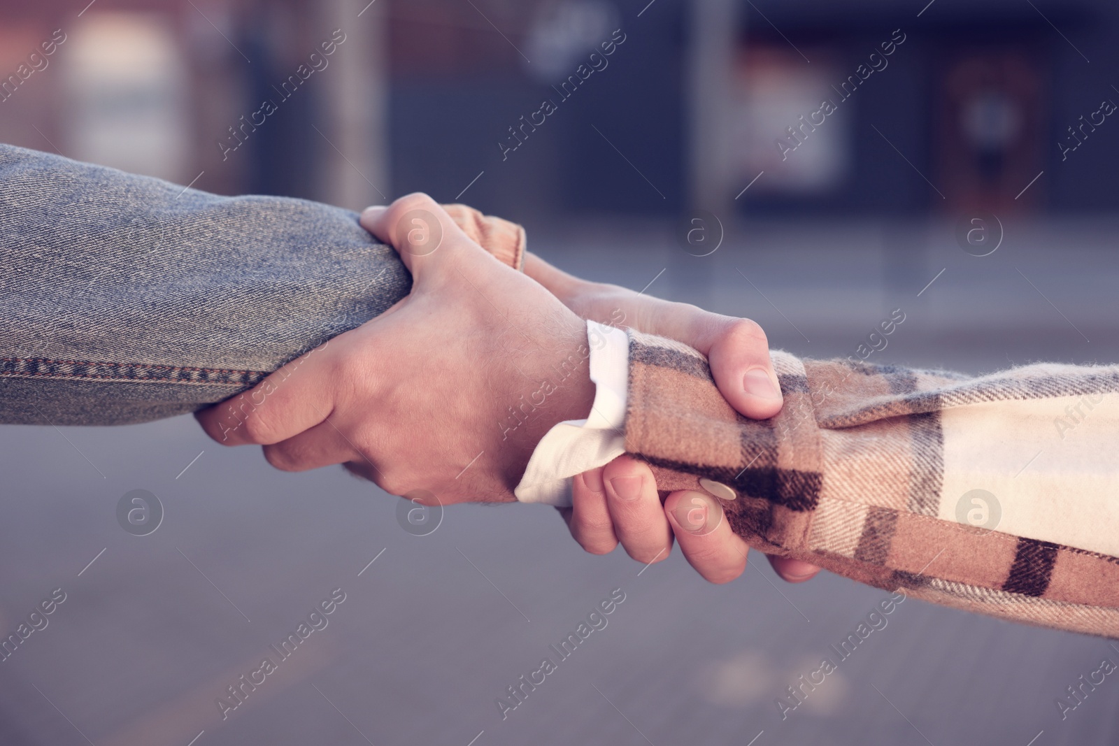 Photo of Help and support. People holding hands on city street, closeup