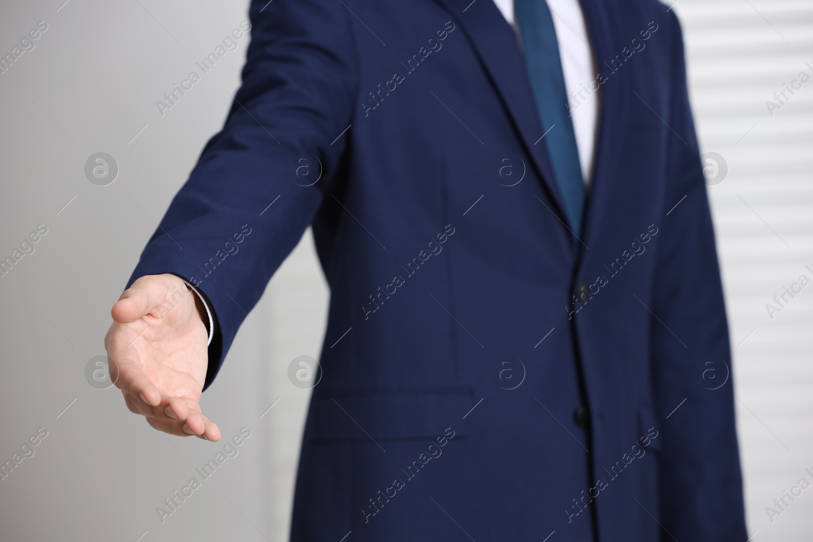 Photo of Man offering helping hand on light background, closeup