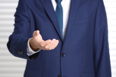 Man offering helping hand on light background, closeup