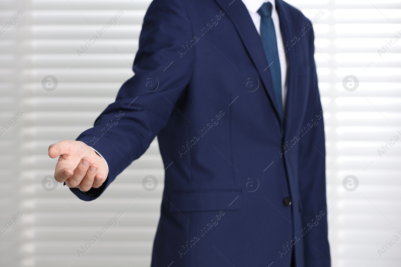 Photo of Man offering helping hand on light background, closeup