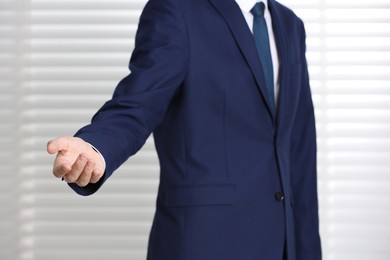 Man offering helping hand on light background, closeup