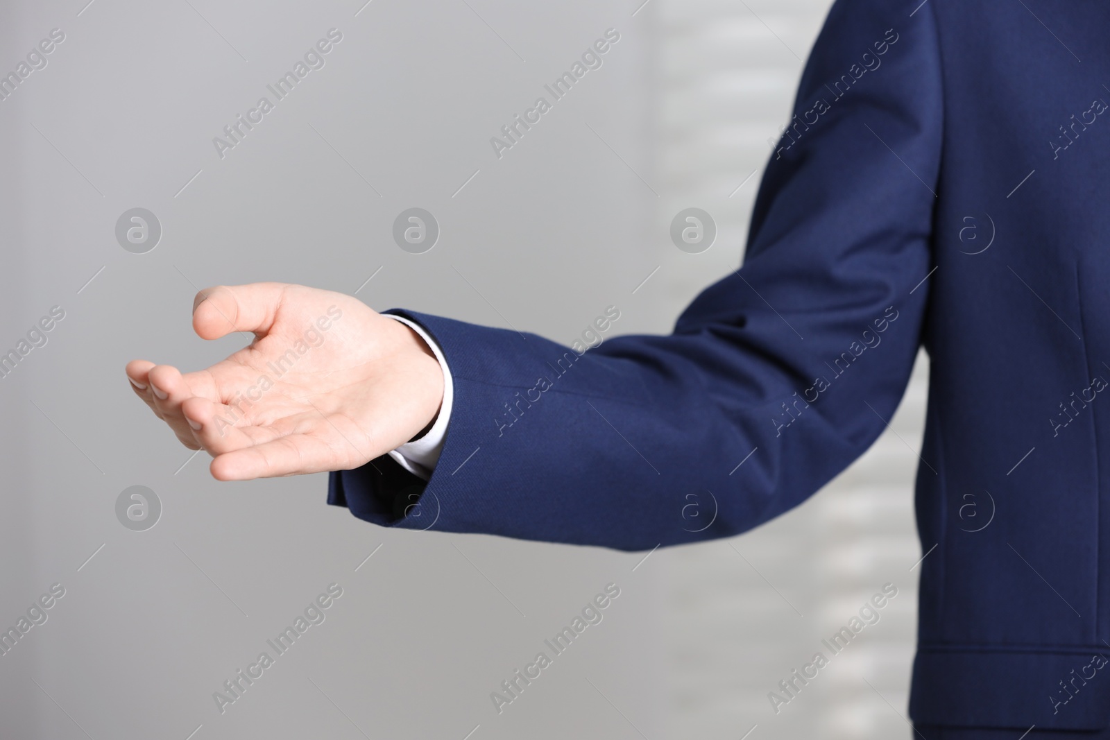 Photo of Man offering helping hand on light background, closeup