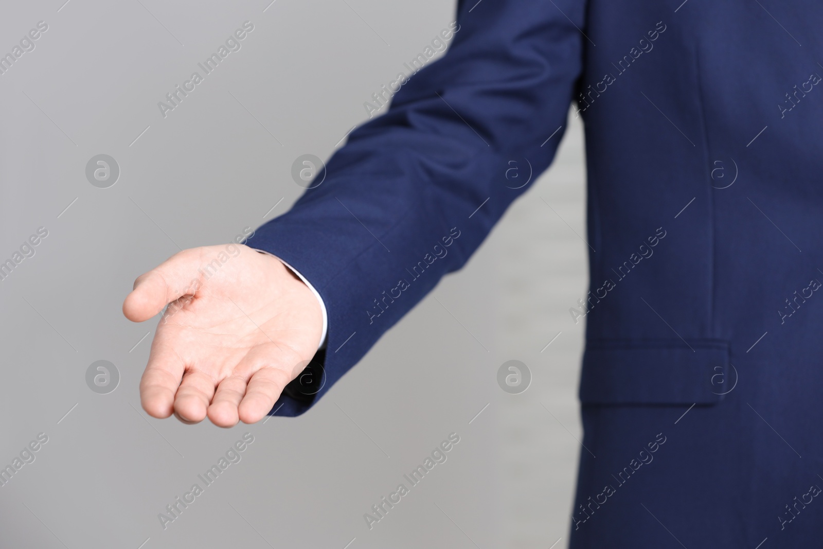 Photo of Man offering helping hand on light background, closeup