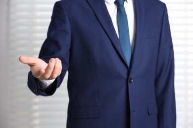 Photo of Man offering helping hand on light background, closeup