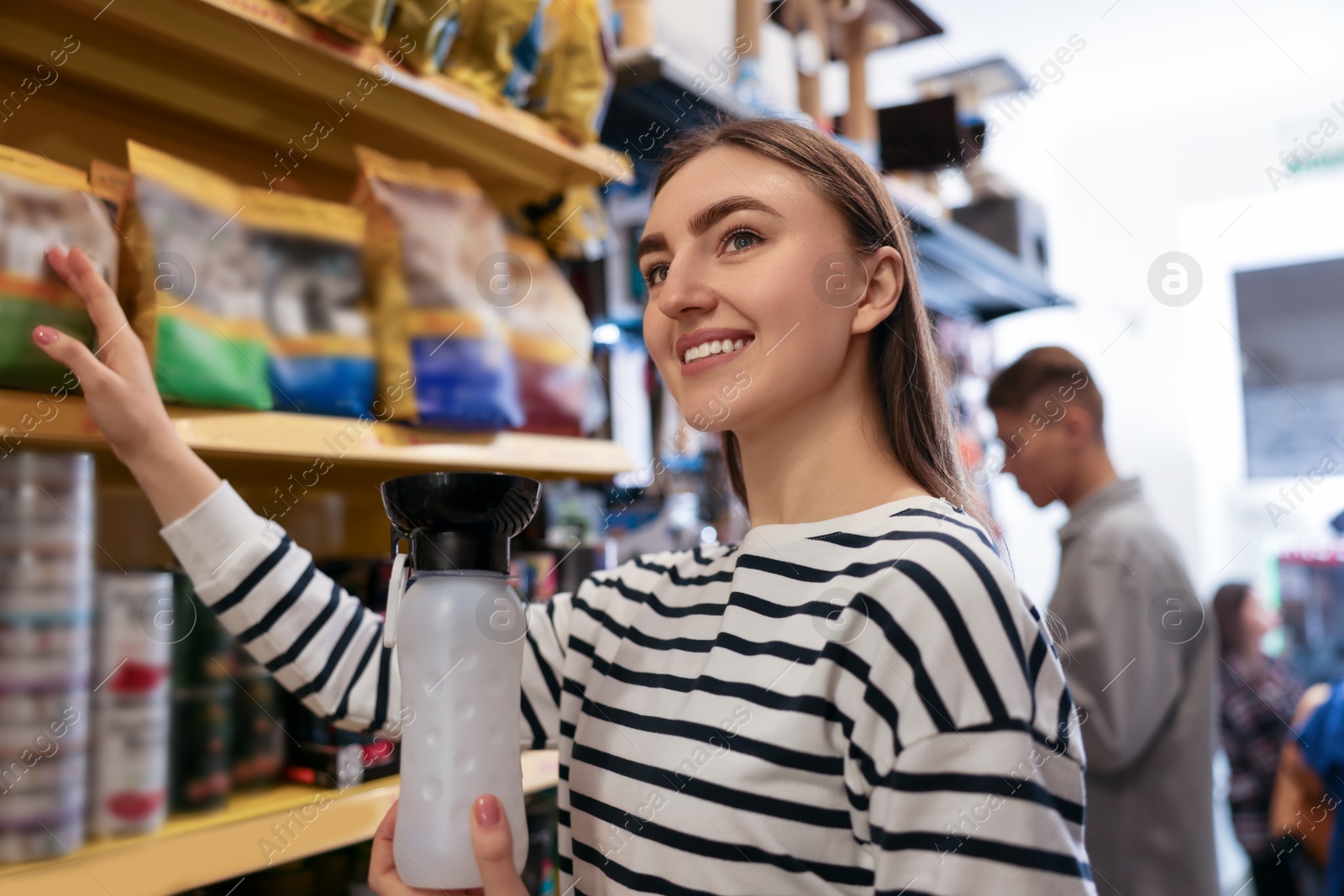 Photo of Woman with dog water bottle in pet shop