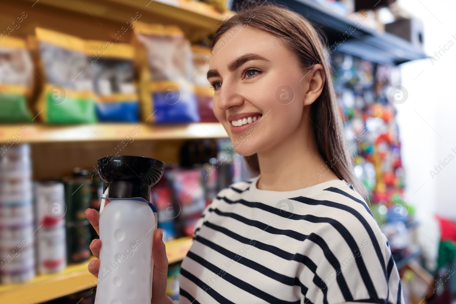 Photo of Woman with dog water bottle in pet shop