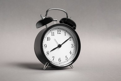 Photo of One black alarm clock on grey background