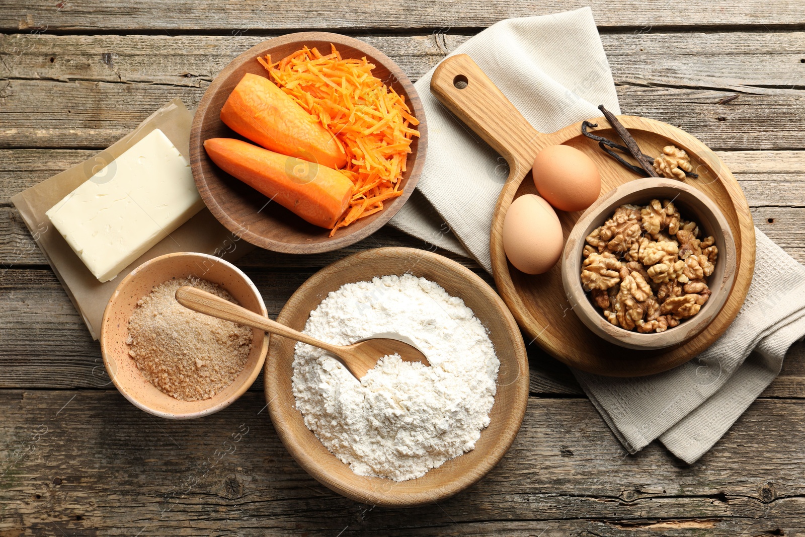 Photo of Different ingredients for making carrot cake on wooden table, flat lay