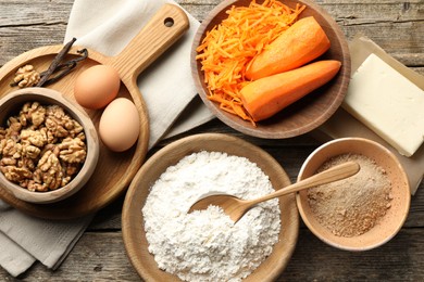 Photo of Different ingredients for making carrot cake on wooden table, flat lay