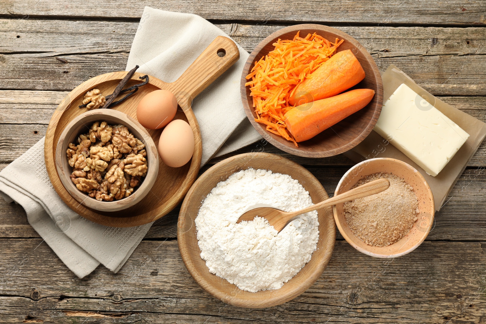 Photo of Different ingredients for making carrot cake on wooden table, flat lay