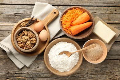 Photo of Different ingredients for making carrot cake on wooden table, flat lay