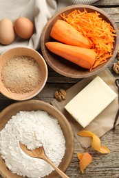 Photo of Different ingredients for making carrot cake on wooden table, flat lay