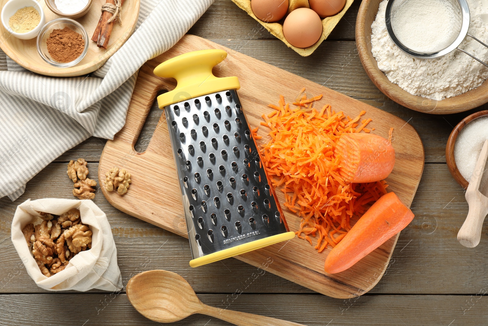 Photo of Different ingredients for making carrot cake and kitchenware on wooden table, flat lay