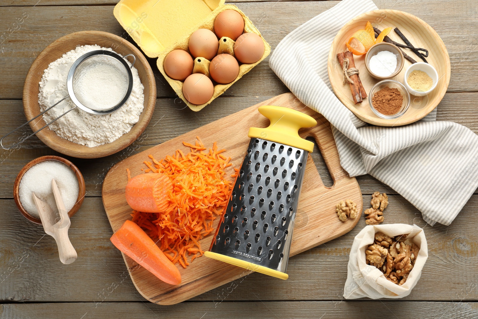 Photo of Different ingredients for making carrot cake and kitchenware on wooden table, flat lay