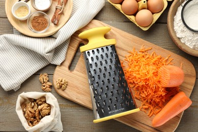 Photo of Different ingredients for making carrot cake and kitchenware on wooden table, flat lay