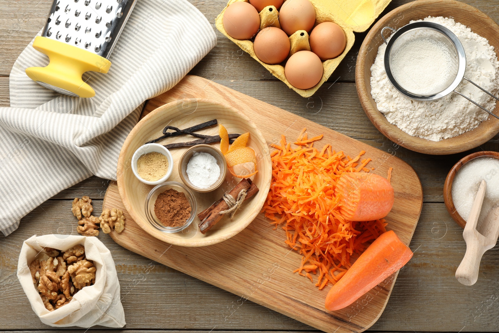 Photo of Different ingredients for making carrot cake and kitchenware on wooden table, flat lay