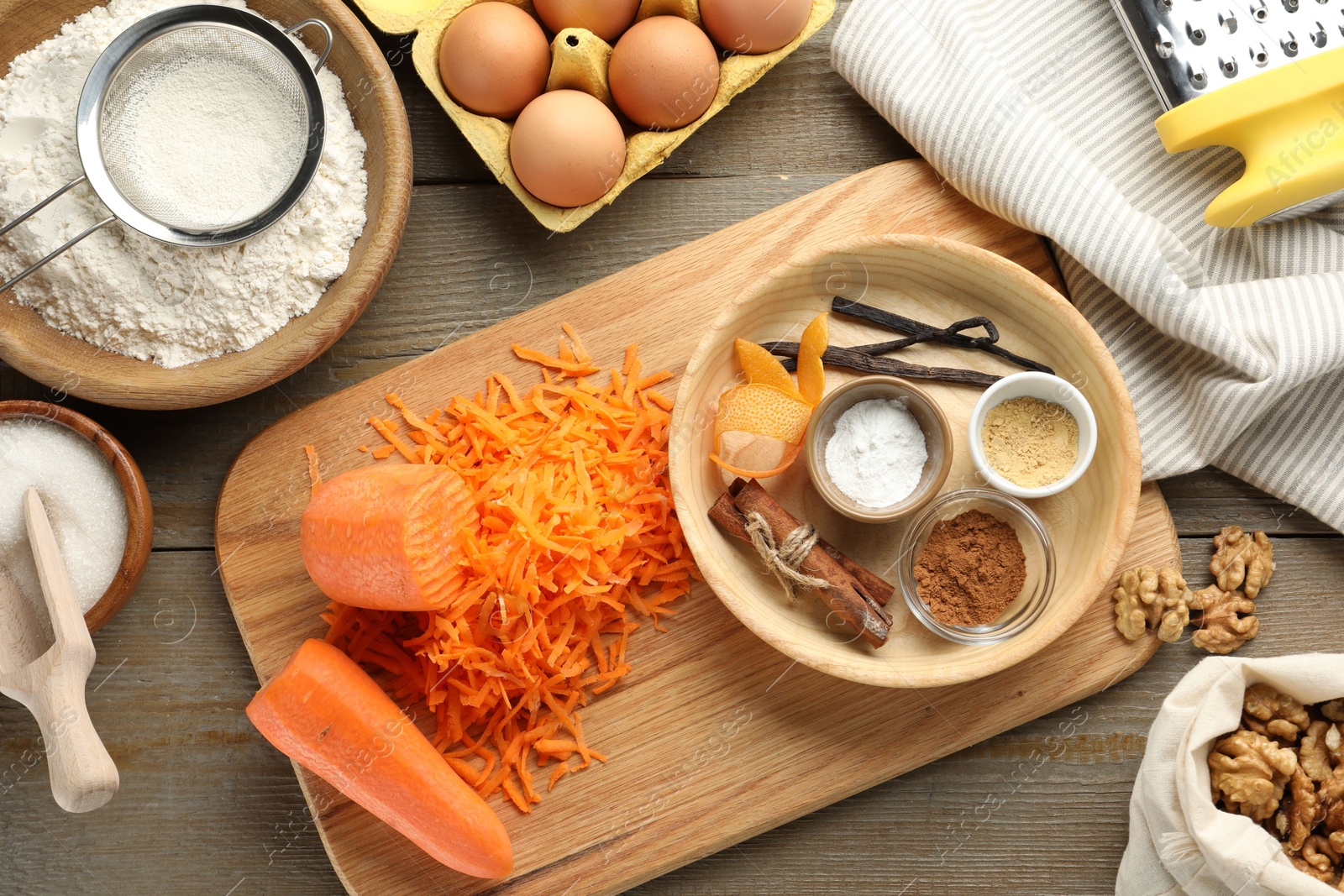 Photo of Different ingredients for making carrot cake and kitchenware on wooden table, flat lay