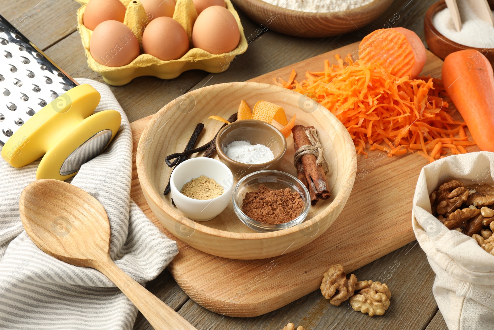 Photo of Different ingredients for making carrot cake and kitchenware on wooden table