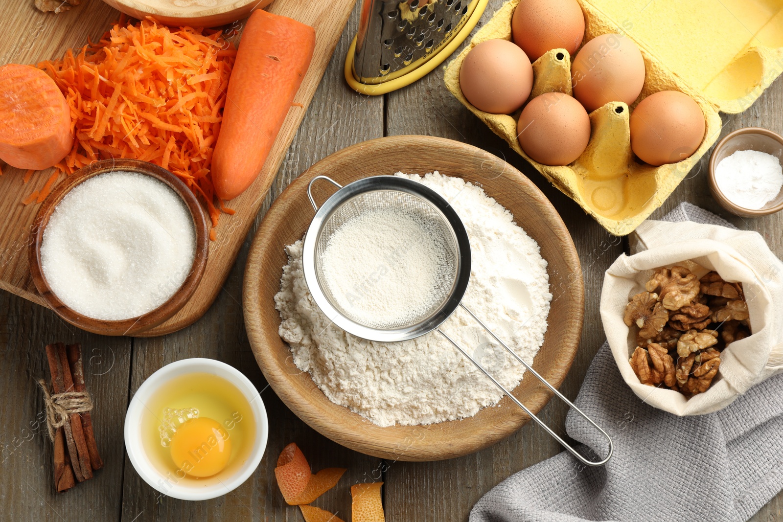 Photo of Different ingredients for making carrot cake and kitchenware on wooden table, flat lay