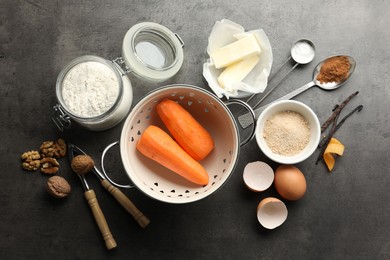 Photo of Different ingredients for making carrot cake and kitchenware on dark textured table, flat lay