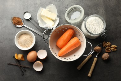 Photo of Different ingredients for making carrot cake and kitchenware on dark textured table, flat lay