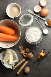 Photo of Different ingredients for making carrot cake and kitchenware on dark textured table, flat lay