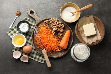 Photo of Different ingredients for making carrot cake and kitchenware on dark textured table, flat lay