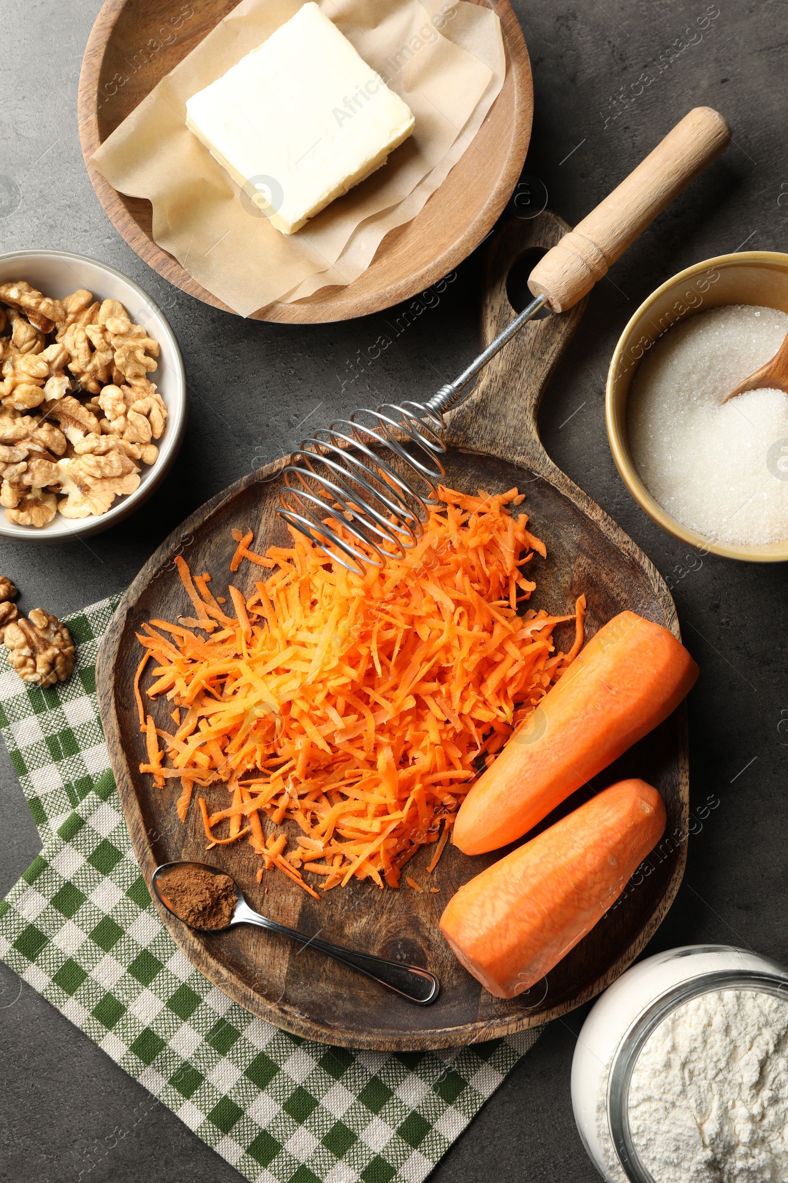 Photo of Different ingredients for making carrot cake and kitchenware on dark textured table, flat lay