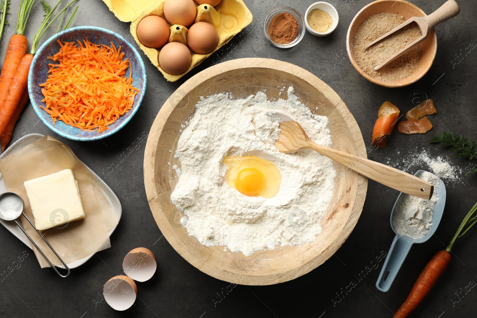 Photo of Making carrot cake. Different ingredients for dough and kitchenware on dark textured table, flat lay