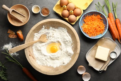 Photo of Making carrot cake. Different ingredients for dough and kitchenware on dark textured table, flat lay