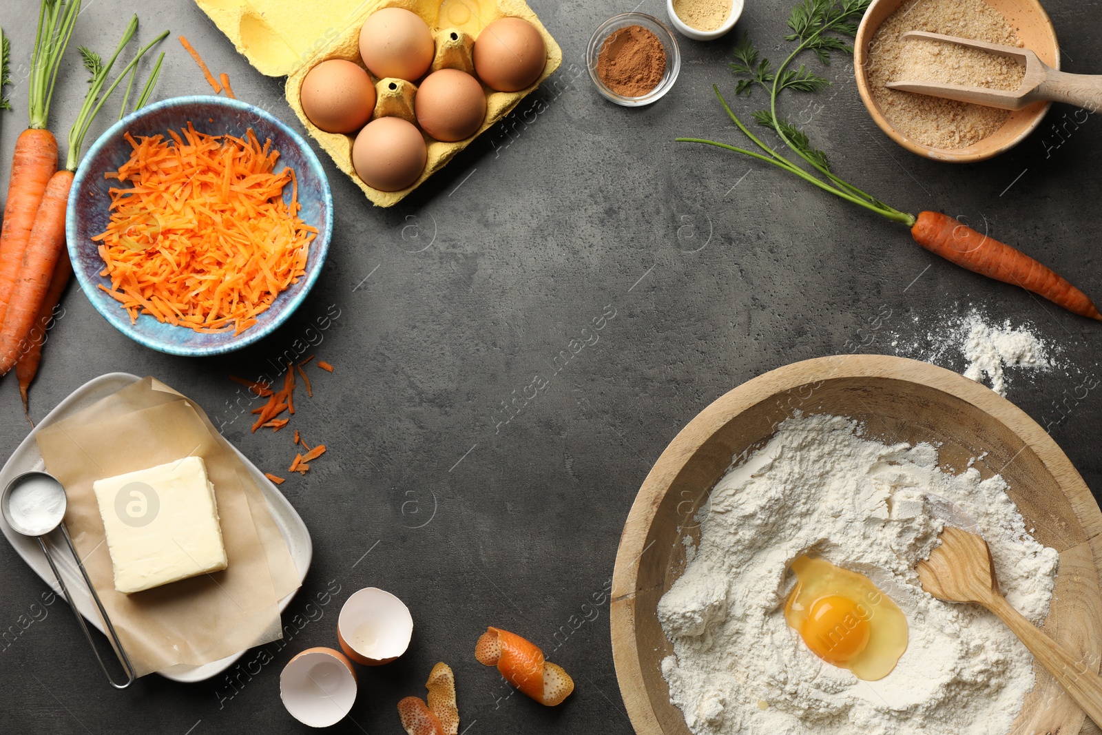 Photo of Making carrot cake. Different ingredients for dough and kitchenware on dark textured table, flat lay. Space for text