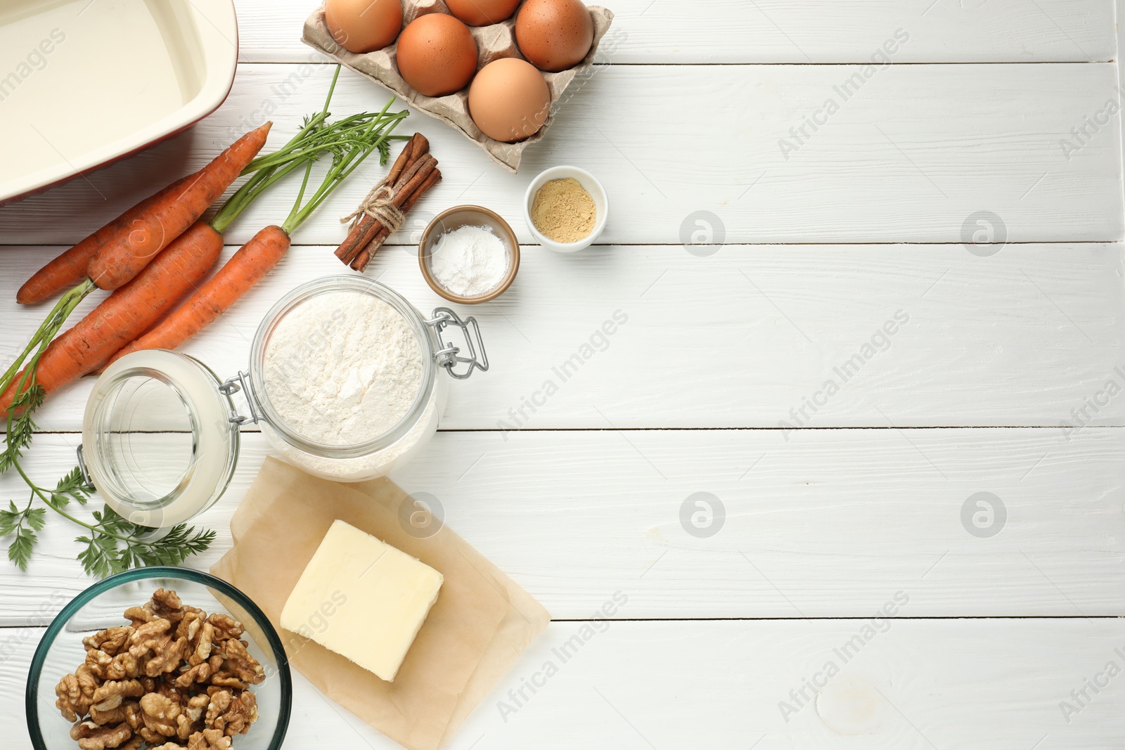 Photo of Different ingredients for making carrot cake on white wooden table, flat lay. Space for text