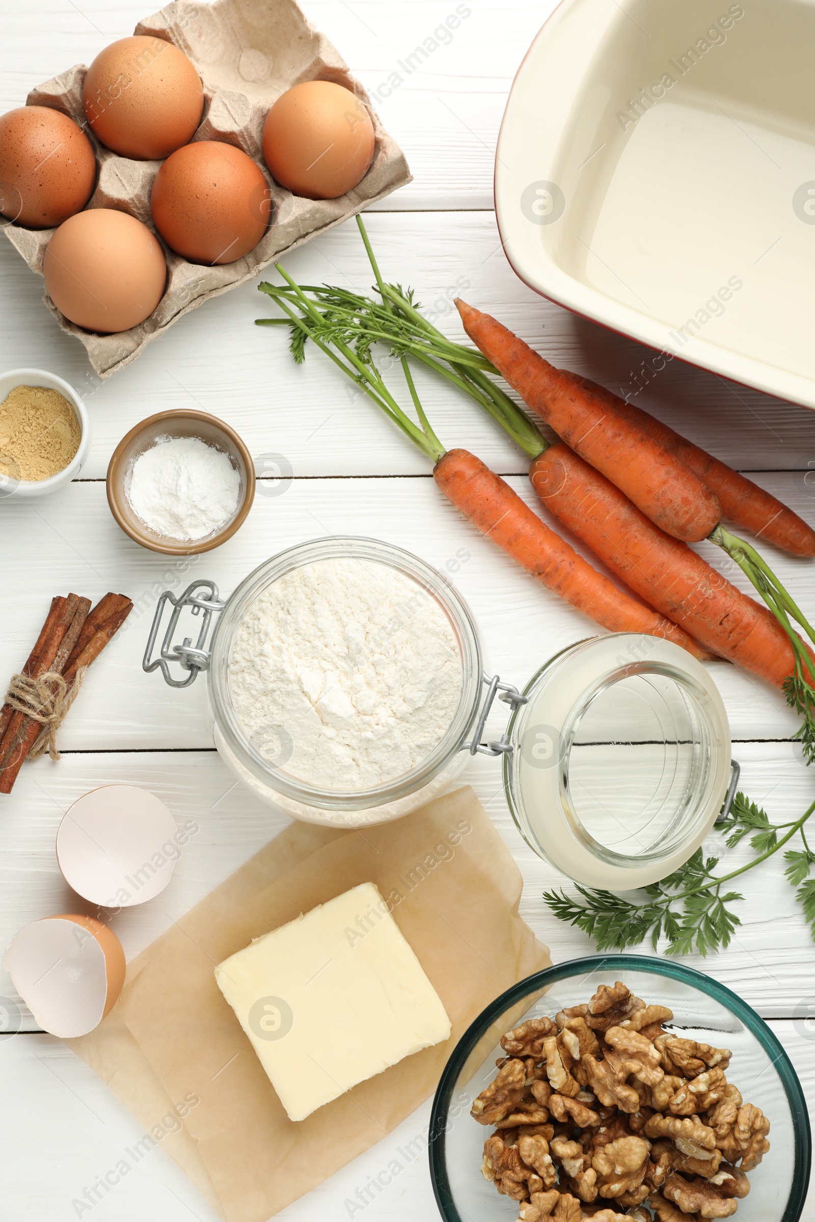 Photo of Different ingredients for making carrot cake on white wooden table, flat lay