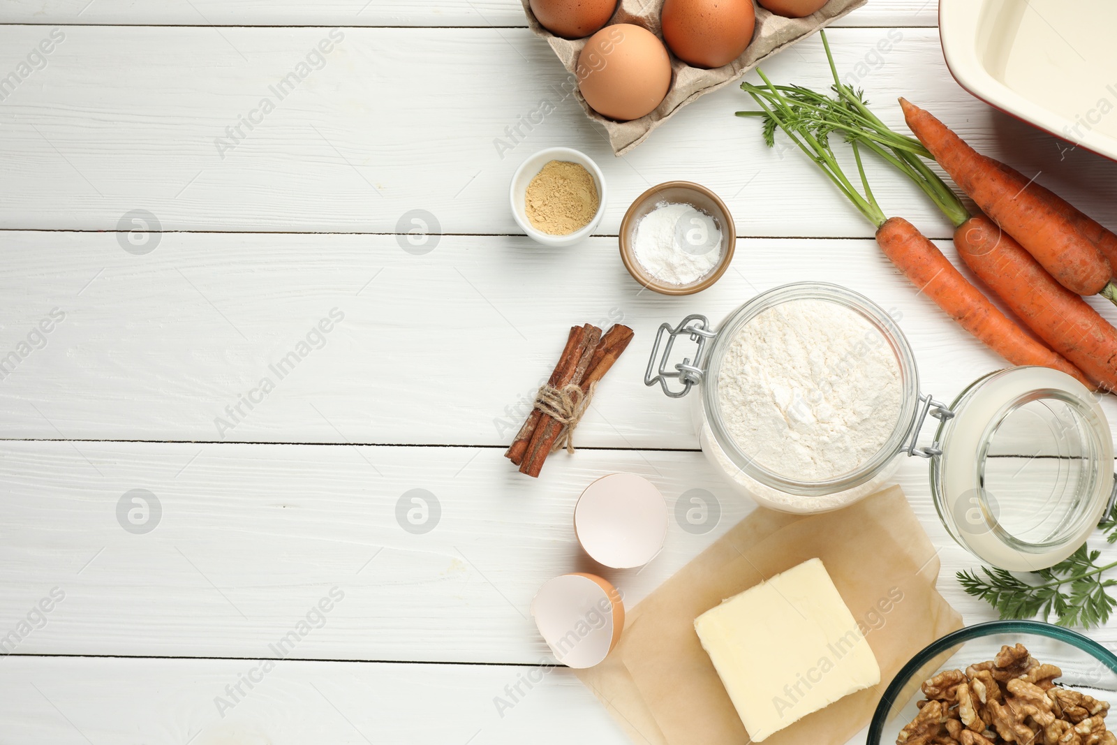 Photo of Different ingredients for making carrot cake on white wooden table, flat lay. Space for text