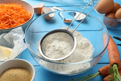 Photo of Different ingredients for making carrot cake on light blue wooden table, closeup