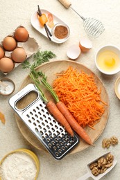 Photo of Different ingredients for making carrot cake on beige textured table, flat lay