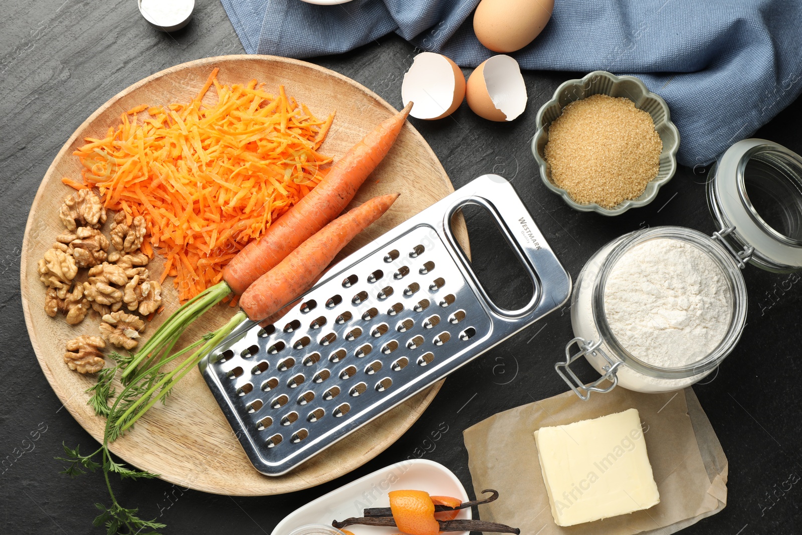 Photo of Different ingredients for making carrot cake on black table, flat lay