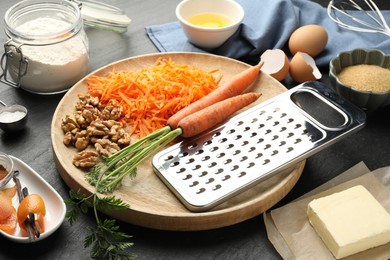 Photo of Different ingredients for making carrot cake on black table, closeup