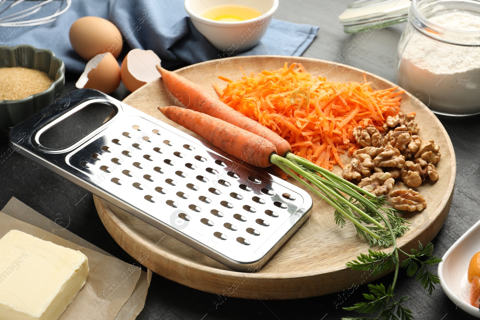 Photo of Different ingredients for making carrot cake on black table, closeup