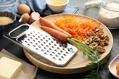 Photo of Different ingredients for making carrot cake on black table, closeup