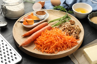 Photo of Different ingredients for making carrot cake on black table, closeup