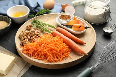 Photo of Different ingredients for making carrot cake on black table, closeup