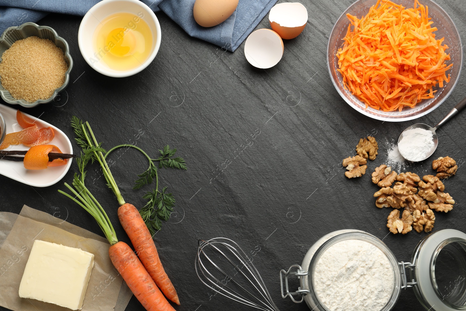 Photo of Frame of different ingredients for making carrot cake on black table, flat lay. Space for text