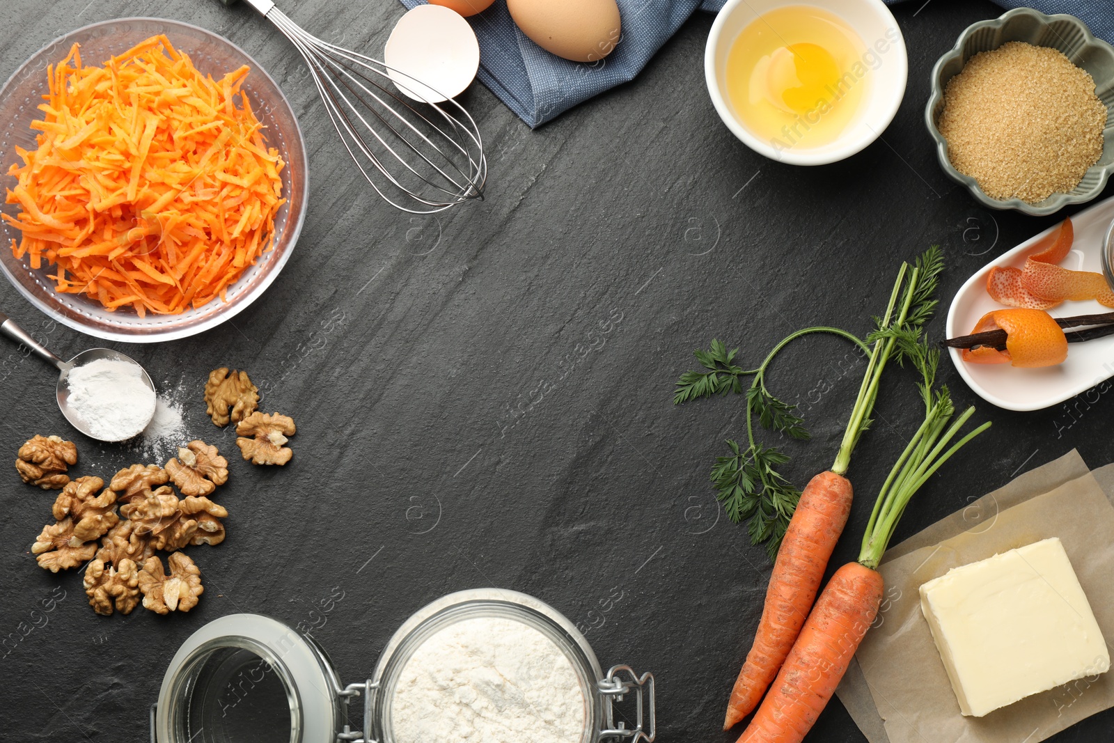 Photo of Frame of different ingredients for making carrot cake on black table, flat lay. Space for text