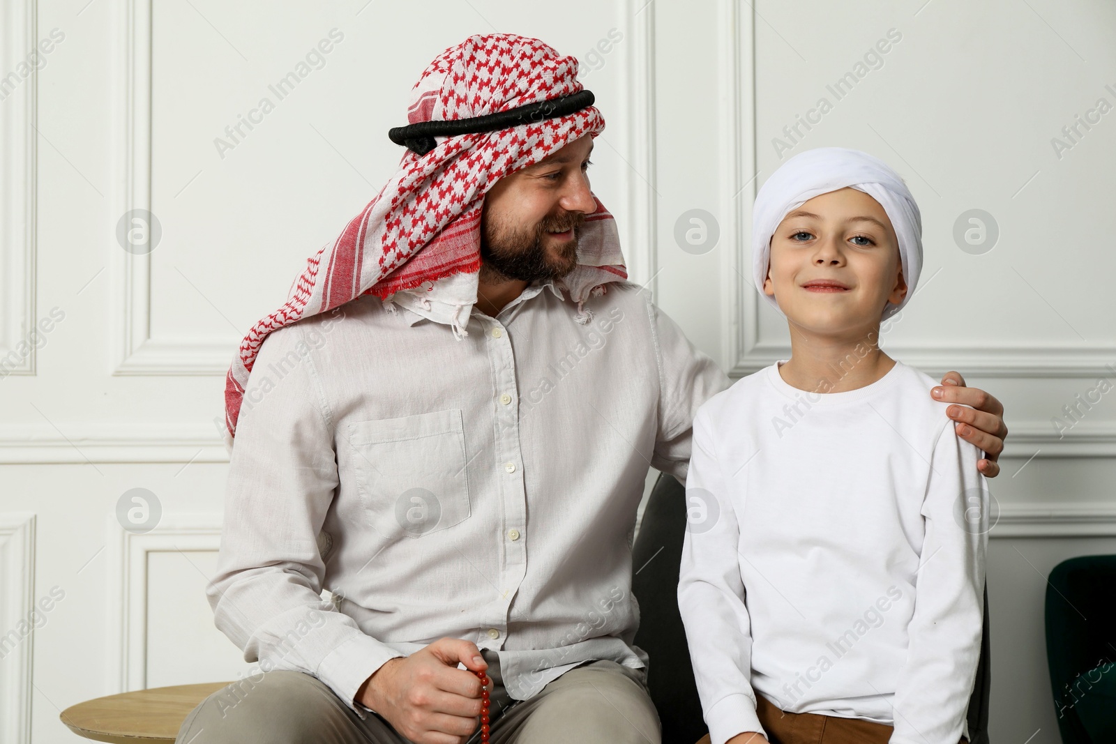 Photo of Muslim man and his son spending time together at home