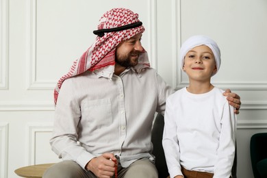 Muslim man and his son spending time together at home