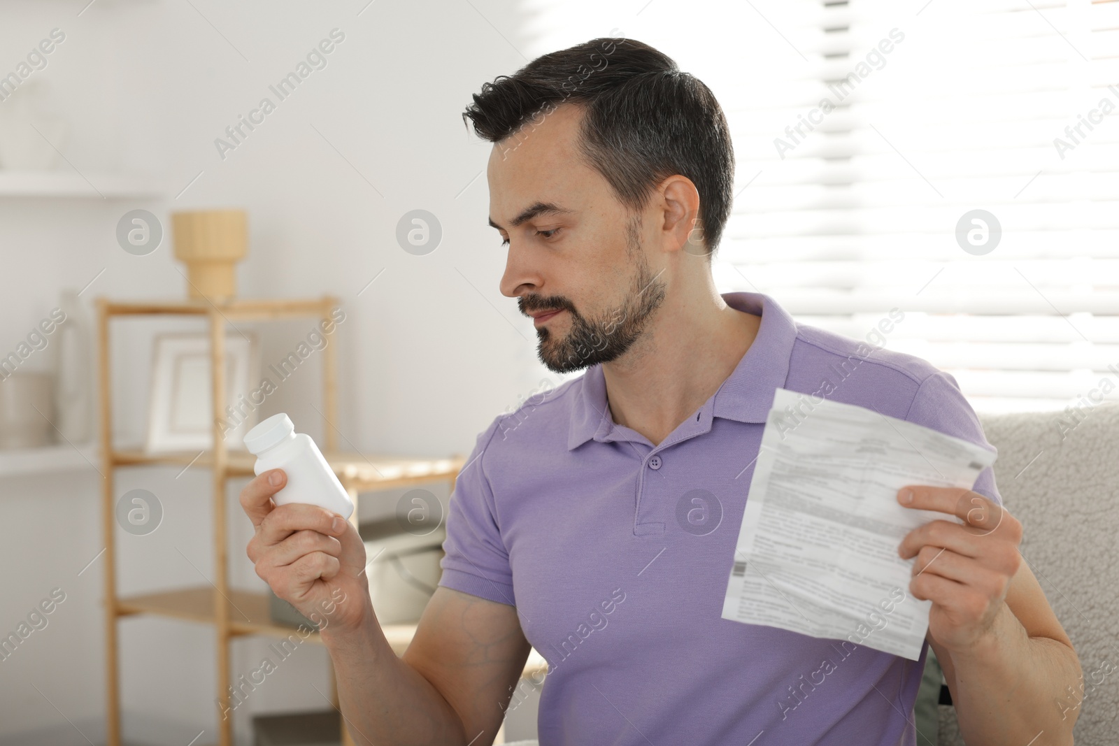 Photo of Man with pills reading instruction at home