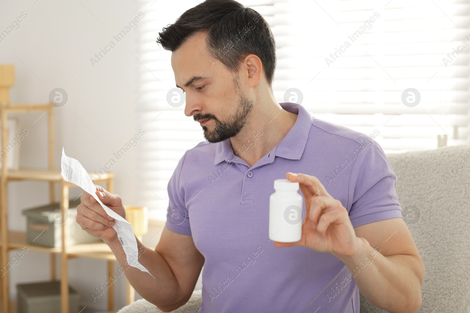 Photo of Man with pills reading instruction at home