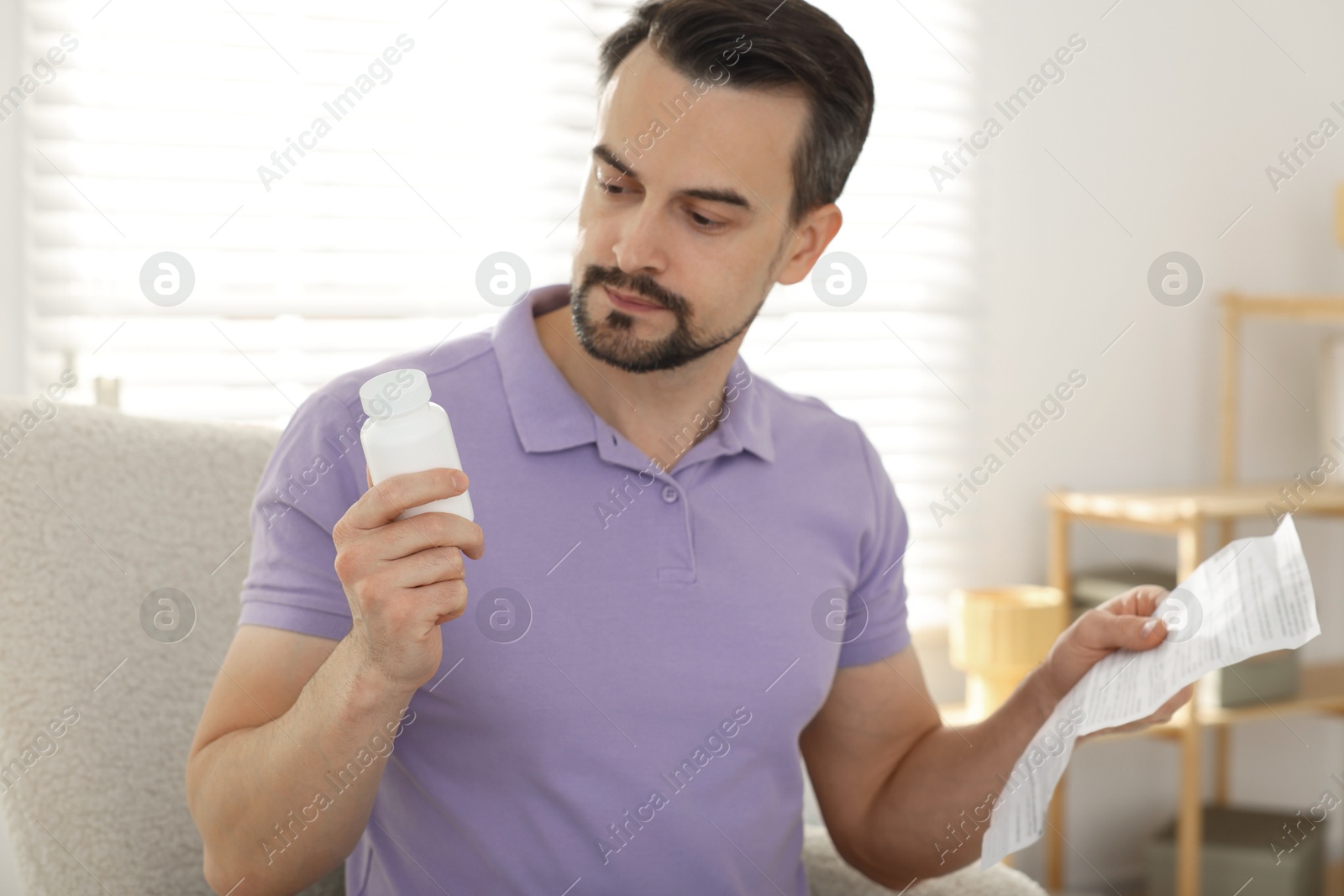 Photo of Man with pills and medical instruction at home