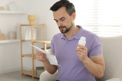 Photo of Man with pills reading instruction at home